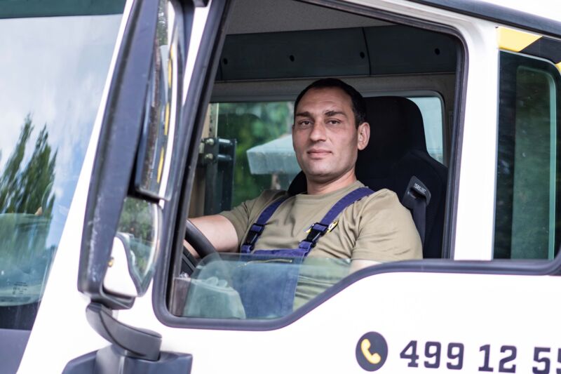 EIn Mitarbeiter sitzt im LKW und guckt aus dem Fenster. Nahe Aufnahme