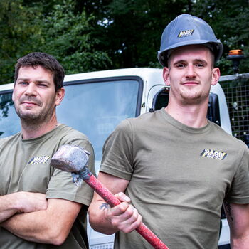 Porträt zweier Mitarbeiter bei HASU Abbruch. Ein Mitarbeiter hält einen Vorschlaghammer.