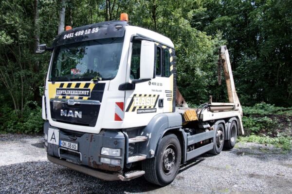 Ein LKW der Firma HASU Abbruch GmbH mit dem Logo der Firma HASU und einer Ladefläche für Container.