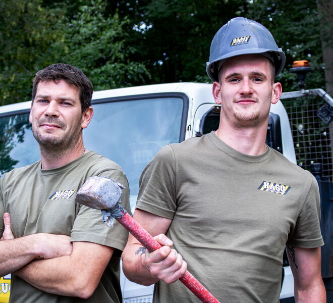 Porträt zweier Mitarbeiter bei HASU Abbruch. Ein Mitarbeiter hält einen Vorschlaghammer.