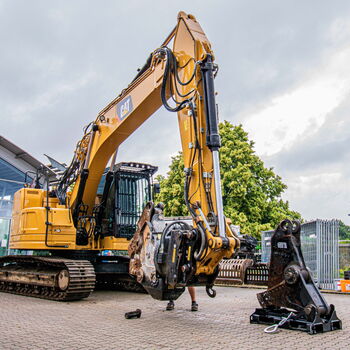 Ein Bagger entfernt bei einem Abbruchprojekt mit seinem Greifer alte Baumaterialien.